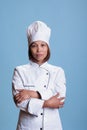 Elderly cheerful chef standing with arm crossed in studio preparing culinary recipe