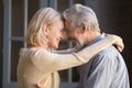 Elderly cheerful couple embracing looks at each other with love Royalty Free Stock Photo