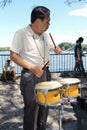 Elderly Chinese man playing drum in a park in Beijing