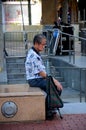 Elderly Chinese man sits and contemplates life Singapore