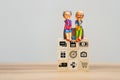 Elderly clay doll on wooden cube block. Retirement Planning Ideas, saving money, retirement, health care.
