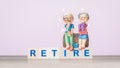 Elderly clay doll on wooden cube block with the word retired on wood table.