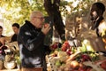 Elderly client smelling bio apples and standing near farmers food market Royalty Free Stock Photo