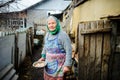 The elderly countrywoman gathers eggs in a hen house.