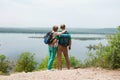 Elderly couple with backpacks travels around mountains.