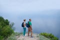 Elderly couple with backpacks travels around mountains.