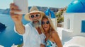 Elderly couple capturing happy moments in old city while taking selfie on vacation Royalty Free Stock Photo