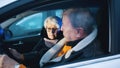 Elderly couple in the car confused with flashing police lights. Speeding ticket. Man and woman having argument in the Royalty Free Stock Photo