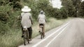 An elderly couple carefully cycled together on the highway, with their husband taking care of them behind them.Concepts about Royalty Free Stock Photo