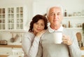 elderly couple drinking coffee in the kitchen while sitting at the table. Royalty Free Stock Photo