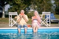 Elderly couple  eating watermelon by the pool.Man and woman enjoy on summer holiday Royalty Free Stock Photo