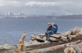 Elderly couple enjoying view of the ocean sitting on the rocky coastline in White Rock BC