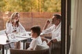 An elderly couple enjoys the terrace of a luxury house with their son during the holidays. Selective focus Royalty Free Stock Photo