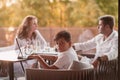 An elderly couple enjoys the terrace of a luxury house with their son during the holidays. Selective focus Royalty Free Stock Photo