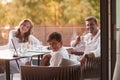 An elderly couple enjoys the terrace of a luxury house with their son during the holidays. Selective focus Royalty Free Stock Photo