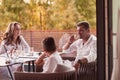 An elderly couple enjoys the terrace of a luxury house with their son during the holidays. Selective focus Royalty Free Stock Photo