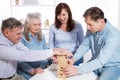 Elderly couple with family Closeup making a pyramid with empty wooden cubes close up