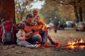 An elderly couple and grandchildren playing guitar in the forest around a campfire Royalty Free Stock Photo