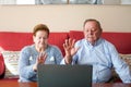 an elderly couple greets a doctor via video-conference