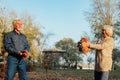 Elderly couple happily throws autumn fall leaves sitting in a park. Positive emotions of the elderly