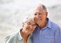 Elderly, couple and happy portrait at beach for retirement vacation or anniversary to relax with love, care and Royalty Free Stock Photo