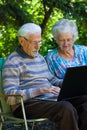 Elderly couple having fun with the laptop outdoors Royalty Free Stock Photo