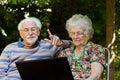 Elderly couple having fun with the laptop outdoors Royalty Free Stock Photo