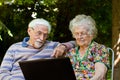 Elderly couple having fun with the laptop outdoors Royalty Free Stock Photo