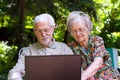 Elderly couple having fun with the laptop outdoors Royalty Free Stock Photo