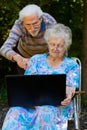 Elderly couple having fun with the laptop outdoors Royalty Free Stock Photo