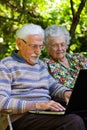 Elderly couple having fun with the laptop outdoors Royalty Free Stock Photo