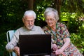 Elderly couple having fun with the laptop outdoors Royalty Free Stock Photo