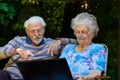 Elderly couple having fun with the laptop outdoors Royalty Free Stock Photo