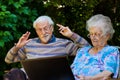 Elderly couple having fun with the laptop outdoors Royalty Free Stock Photo