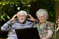 Elderly couple having fun with the laptop outdoors Royalty Free Stock Photo