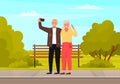 Elderly couple holding mobile phone and taking pictures. Happy people smiling and posing for photo