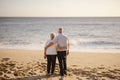 Elderly couple hugging each other on the beach
