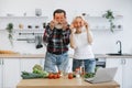 Elderly couple, husband and wife, having fun in kitchen while preparing breakfast. Royalty Free Stock Photo