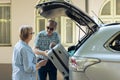 Elderly couple loading trolley in car trunk Royalty Free Stock Photo