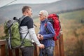 An elderly couple in love having romantic moments on the top of a watchtower in the forest