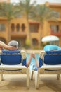 Elderly couple lying by pool Royalty Free Stock Photo