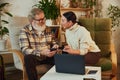 Elderly couple, man and woman sitting at home and buying tickets online, booking hotel and paying online with credit Royalty Free Stock Photo