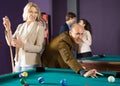 Elderly couple plays billiards