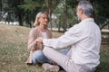 Elderly couple  in practicing yoga while sitting holding to hand together in the public park. Concept of relaxation and meditation Royalty Free Stock Photo