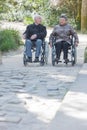 Elderly couple promenading in wheelchairs Royalty Free Stock Photo