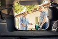 Elderly couple putting travel bags in trunk Royalty Free Stock Photo