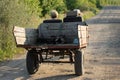 An elderly couple rides in a cart on an old road. Travelers on wheels. By car around the world