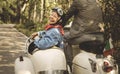 An elderly couple is riding a classic scooter Royalty Free Stock Photo