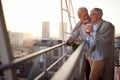 An elderly couple is in romantic moments while they enjoying the view on the city from the terrace of their apartment. Spouses, Royalty Free Stock Photo