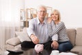 Elderly couple saving money in piggybank at home Royalty Free Stock Photo